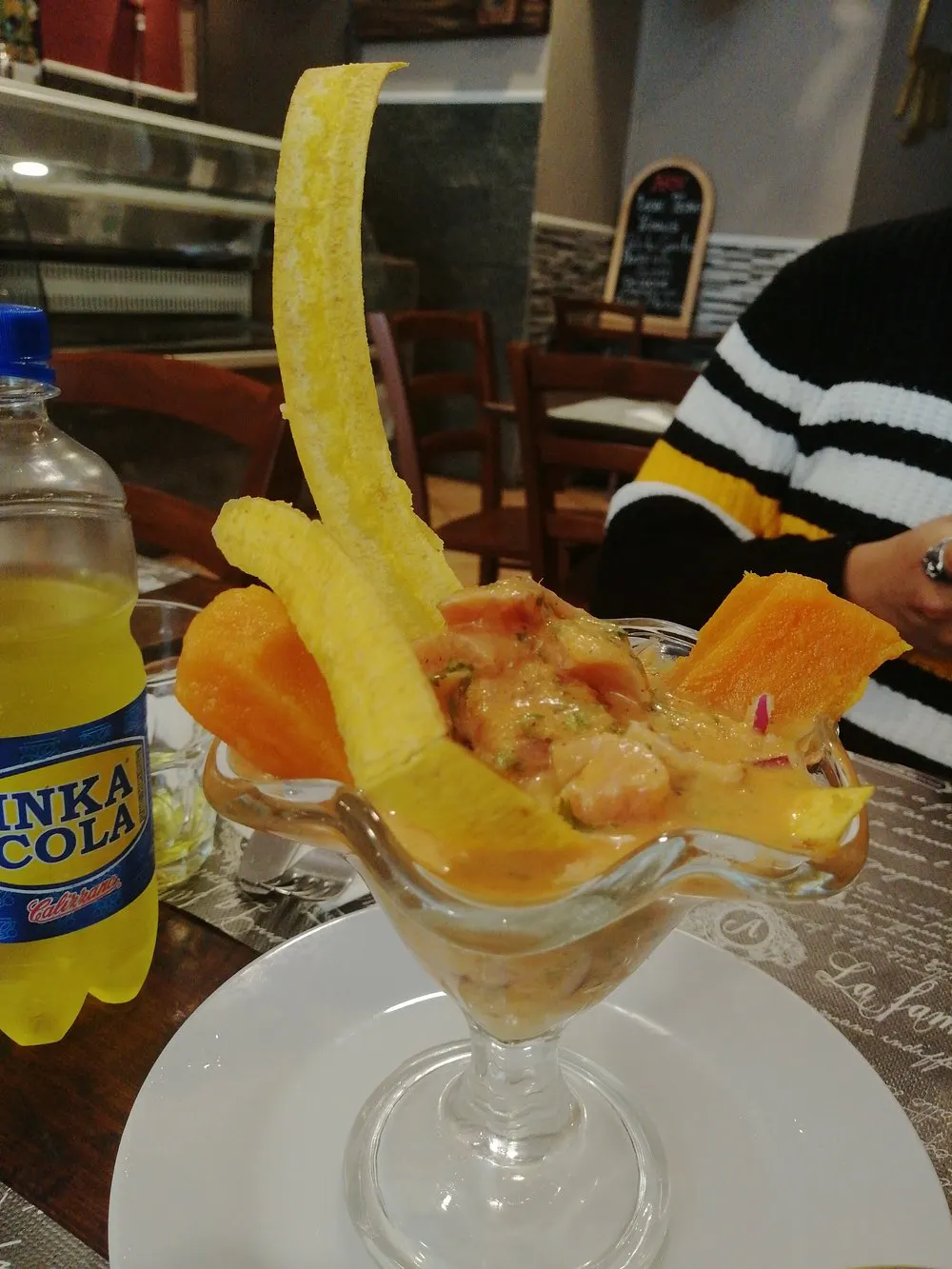 Coppa di ceviche con chifles e bottiglia di Inka Cola